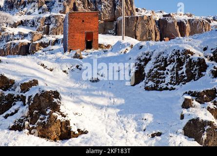 Wintersonne mit blauem Himmel`s, Schnee und Frost bedeckten Harboro Rocks. Harboro Rocks sind ein Rand aus magnesischem Kalkstein in der Nähe von Brassington, Stockfoto